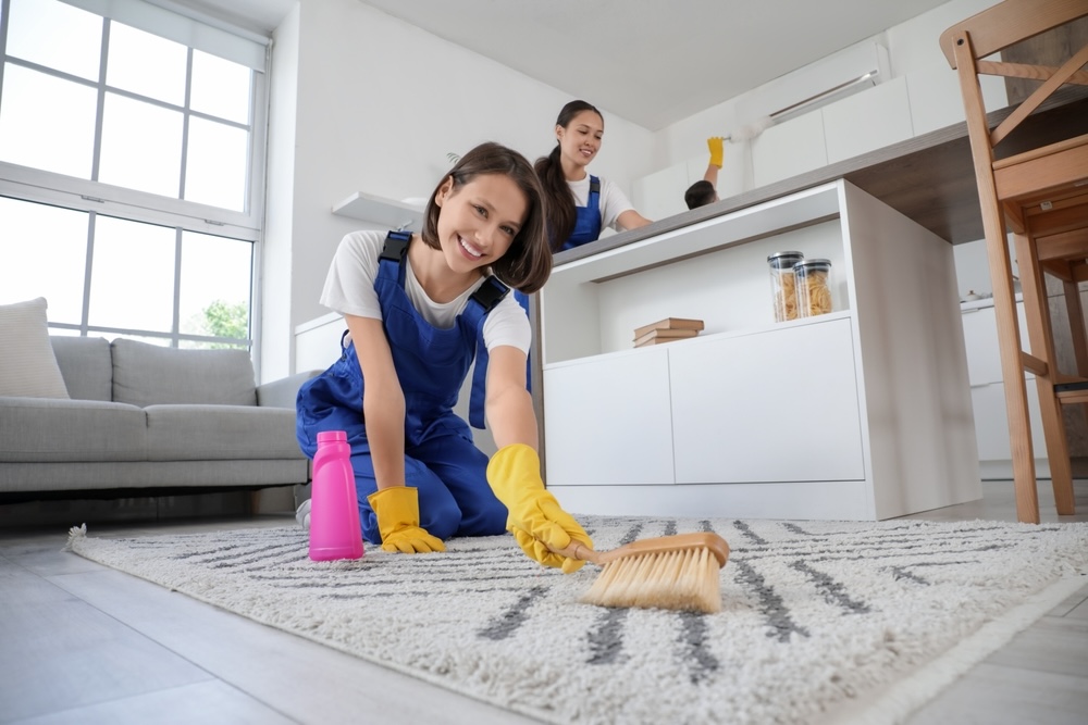 Smiling female carpet cleaners using organic products to clean carpets