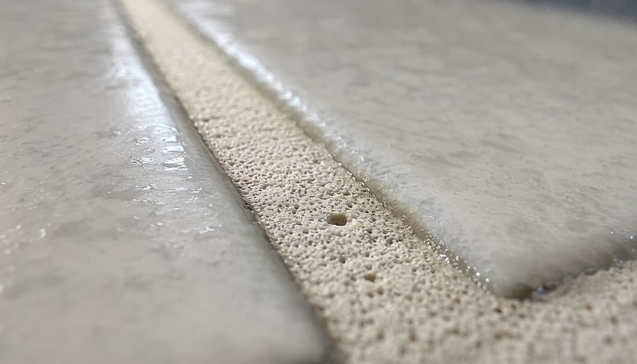 Close-up of porous bathroom tile grout texture
